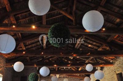 Concert en plein air dans une cour pavée au crépuscule, avec un orchestre et des spectateurs assis sur des chaises blanches.