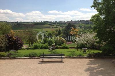 Concert en plein air dans une cour pavée au crépuscule, avec un orchestre et des spectateurs assis sur des chaises blanches.