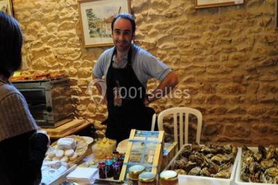 Concert en plein air dans une cour pavée au crépuscule, avec un orchestre et des spectateurs assis sur des chaises blanches.