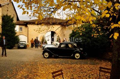 Concert en plein air dans une cour pavée au crépuscule, avec un orchestre et des spectateurs assis sur des chaises blanches.