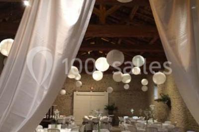 Concert en plein air dans une cour pavée au crépuscule, avec un orchestre et des spectateurs assis sur des chaises blanches.