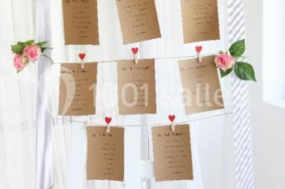 Chaises blanches disposées en rangées sur une pelouse, avec une allée centrale décorée pour une cérémonie en extérieur.