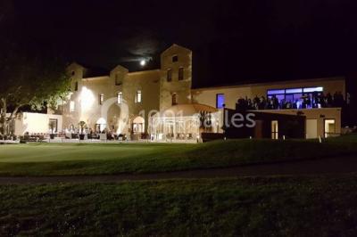 Chaises blanches disposées en rangées sur une pelouse, avec une allée centrale décorée pour une cérémonie en extérieur.