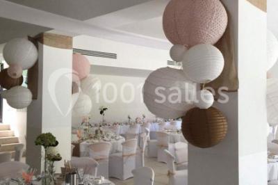 Chaises blanches disposées en rangées sur une pelouse, avec une allée centrale décorée pour une cérémonie en extérieur.