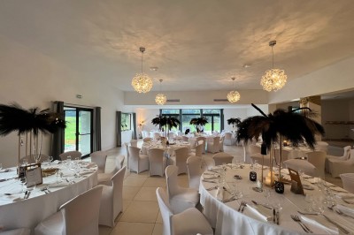 Une mariée en robe blanche danse en extérieur, tenant des rubans entourée d'invités en tenue de soirée.
