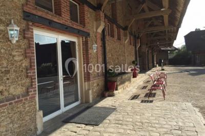 Un groupe de femmes, dont une en robe blanche, marche sur une pelouse devant un bâtiment en pierre et bois.
