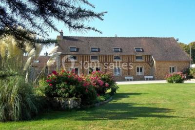 Un groupe de femmes, dont une en robe blanche, marche sur une pelouse devant un bâtiment en pierre et bois.