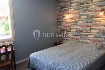 Un groupe de femmes, dont une en robe blanche, marche sur une pelouse devant un bâtiment en pierre et bois.