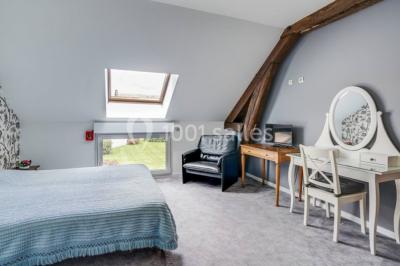 Un groupe de femmes, dont une en robe blanche, marche sur une pelouse devant un bâtiment en pierre et bois.