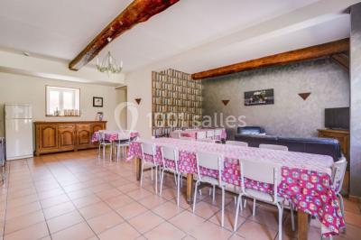 Un groupe de femmes, dont une en robe blanche, marche sur une pelouse devant un bâtiment en pierre et bois.