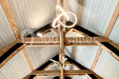 Un groupe de femmes, dont une en robe blanche, marche sur une pelouse devant un bâtiment en pierre et bois.