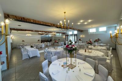 Un groupe de femmes, dont une en robe blanche, marche sur une pelouse devant un bâtiment en pierre et bois.