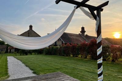 Un groupe de femmes, dont une en robe blanche, marche sur une pelouse devant un bâtiment en pierre et bois.