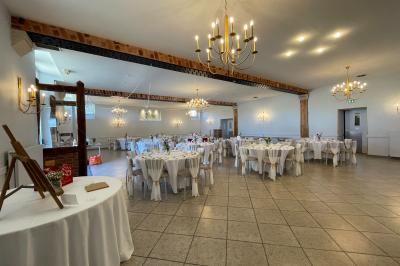 Un groupe de femmes, dont une en robe blanche, marche sur une pelouse devant un bâtiment en pierre et bois.
