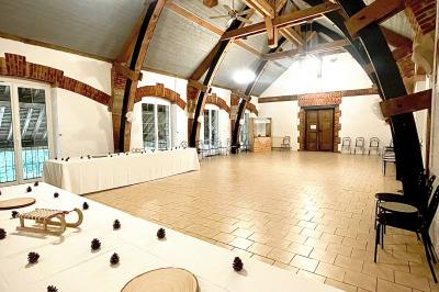 Un groupe de femmes, dont une en robe blanche, marche sur une pelouse devant un bâtiment en pierre et bois.