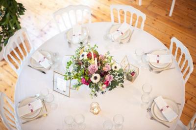 Vue nocturne d'une verrière illuminée par des lumières violettes, entourée d'arbres et d'un jardin.