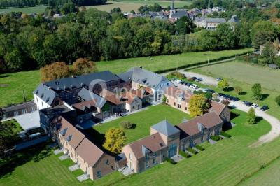 Salle de bain avec baignoire, carrelage blanc et violet, lavabo avec miroir, serviettes pliées et lumière naturelle.