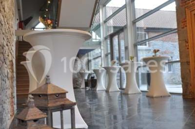 Salle de bain avec baignoire, carrelage blanc et violet, lavabo avec miroir, serviettes pliées et lumière naturelle.