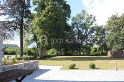 Salle de bain avec baignoire, carrelage blanc et violet, lavabo avec miroir, serviettes pliées et lumière naturelle.