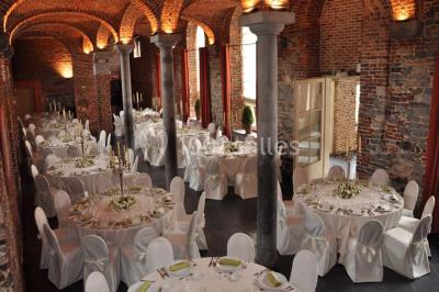 Salle de bain avec baignoire, carrelage blanc et violet, lavabo avec miroir, serviettes pliées et lumière naturelle.