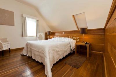 Plafond en bois apparent dans une pièce décorée avec un sapin de Noël blanc, un miroir et des meubles anciens.