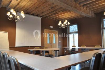 Plafond en bois apparent dans une pièce décorée avec un sapin de Noël blanc, un miroir et des meubles anciens.