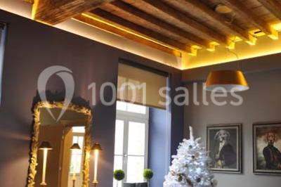 Plafond en bois apparent dans une pièce décorée avec un sapin de Noël blanc, un miroir et des meubles anciens.