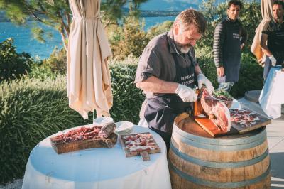 Barques traditionnelles sur une plage bordée de végétation, avec vue sur la mer et des montagnes à l'horizon.