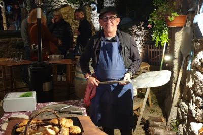 Barques traditionnelles sur une plage bordée de végétation, avec vue sur la mer et des montagnes à l'horizon.