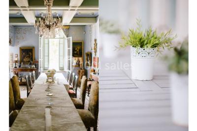 Salle en pierre avec arches, tables décorées et stands alignés, éclairage chaleureux créant une ambiance conviviale.