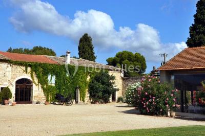 Salle en pierre avec arches, tables décorées et stands alignés, éclairage chaleureux créant une ambiance conviviale.
