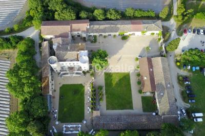 Salle en pierre avec arches, tables décorées et stands alignés, éclairage chaleureux créant une ambiance conviviale.