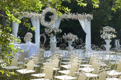 Salle en pierre avec arches, tables décorées et stands alignés, éclairage chaleureux créant une ambiance conviviale.