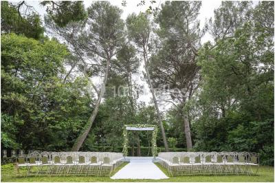 Salle en pierre avec arches, tables décorées et stands alignés, éclairage chaleureux créant une ambiance conviviale.