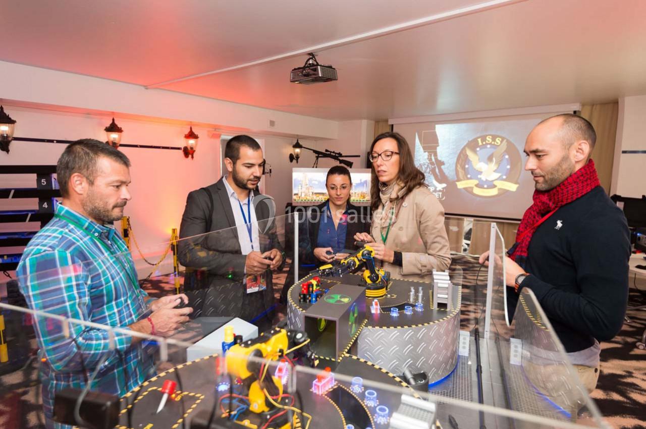 Des personnes participent à une activité collaborative autour d'une table avec des éléments interactifs et technologiques.