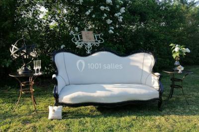 Un tandem décoré de fleurs et d'une caisse en bois, appuyé contre une clôture en bois avec un panneau publicitaire.