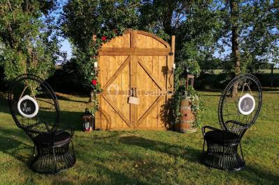 Un tandem décoré de fleurs et d'une caisse en bois, appuyé contre une clôture en bois avec un panneau publicitaire.