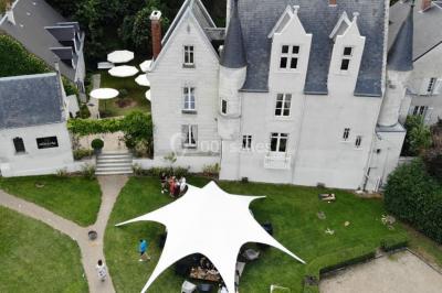 Un tandem décoré de fleurs et d'une caisse en bois, appuyé contre une clôture en bois avec un panneau publicitaire.