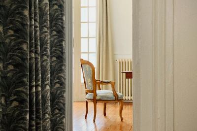 Miniature Location salle Monceaux (Oise) - Domaine de Monceaux #8 Deux fauteuils colorés entourent une table ronde avec une lampe, des livres et un bouquet, sur un sol en damier.