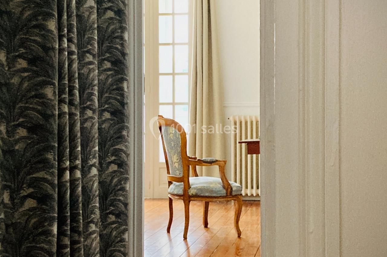 Location salle Monceaux (Oise) - Domaine de Monceaux #8 Une chaise en bois avec assise rembourrée est placée près d'une fenêtre dans une pièce lumineuse au sol en parquet.