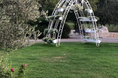 Arrangements floraux sur des supports en bois disposés sur une table recouverte d'une nappe blanche devant un mur en pierre.