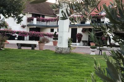 Arrangements floraux sur des supports en bois disposés sur une table recouverte d'une nappe blanche devant un mur en pierre.