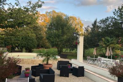 Arrangements floraux sur des supports en bois disposés sur une table recouverte d'une nappe blanche devant un mur en pierre.