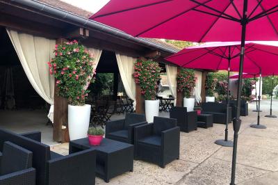 Arrangements floraux sur des supports en bois disposés sur une table recouverte d'une nappe blanche devant un mur en pierre.