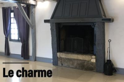 Arrangements floraux sur des supports en bois disposés sur une table recouverte d'une nappe blanche devant un mur en pierre.