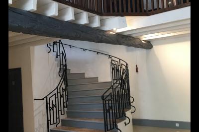 Arrangements floraux sur des supports en bois disposés sur une table recouverte d'une nappe blanche devant un mur en pierre.