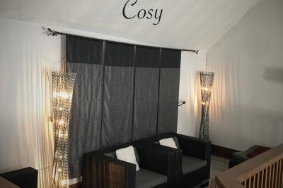 Arrangements floraux sur des supports en bois disposés sur une table recouverte d'une nappe blanche devant un mur en pierre.