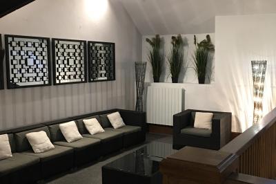 Arrangements floraux sur des supports en bois disposés sur une table recouverte d'une nappe blanche devant un mur en pierre.