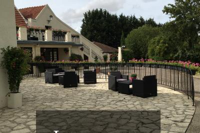 Arrangements floraux sur des supports en bois disposés sur une table recouverte d'une nappe blanche devant un mur en pierre.
