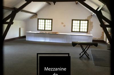 Arrangements floraux sur des supports en bois disposés sur une table recouverte d'une nappe blanche devant un mur en pierre.